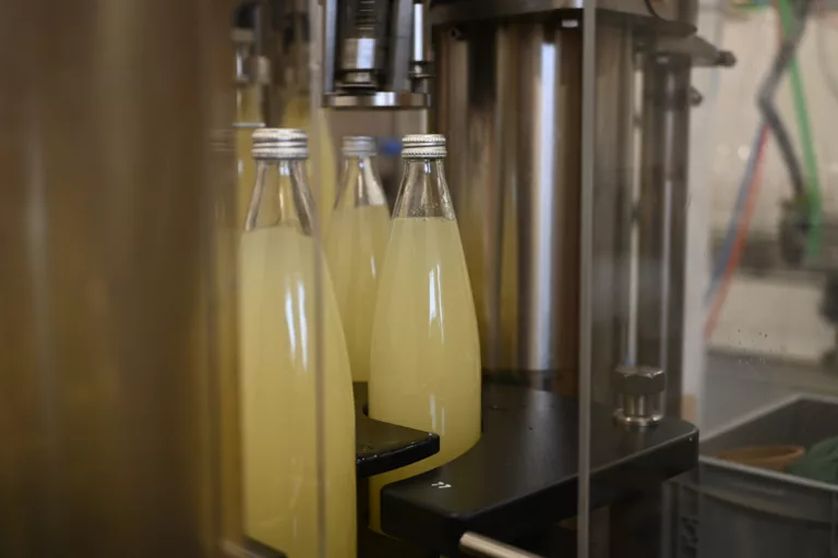 photo de kefir de fruits. Production de kefir de fruits en usine. embouteilleuse automatique.